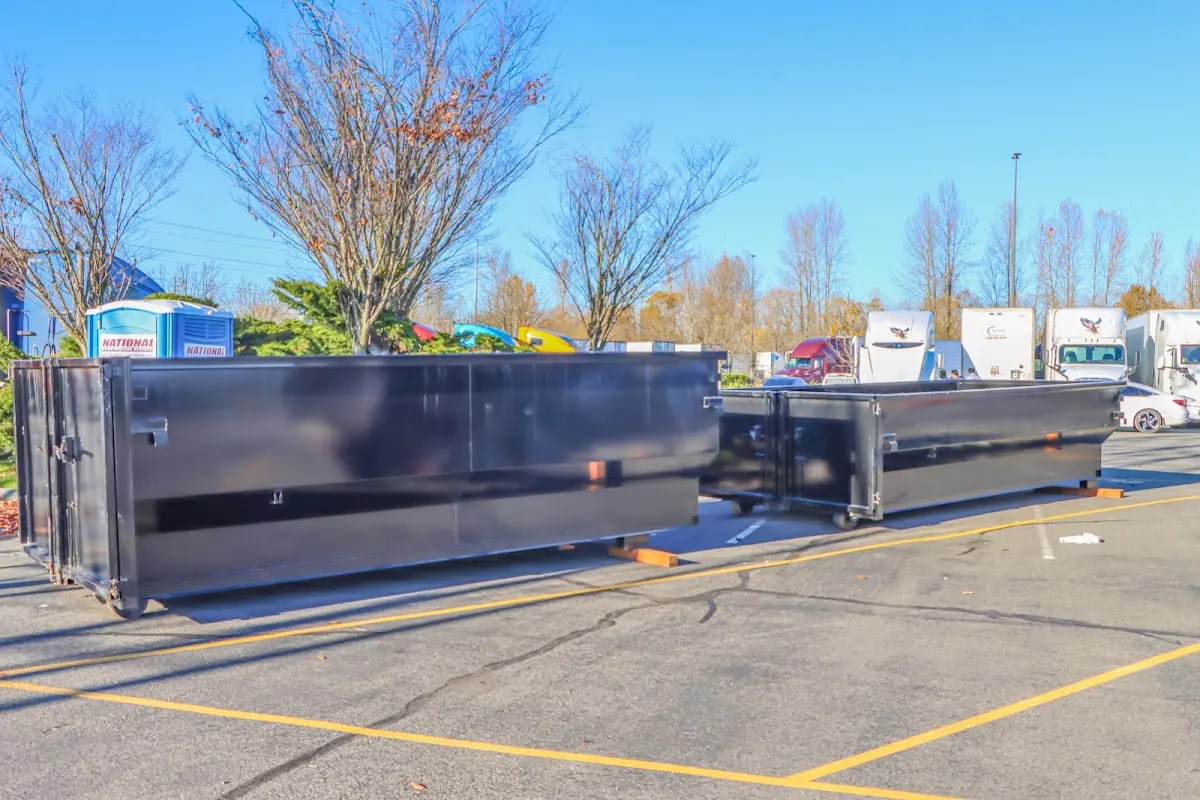 Professional dumpster rental service with roll-off container on residential driveway in Malone